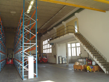Die Halle vor dem Umbau: Hochregale und Gabelstapler prägen den Lagerhallencharakter.