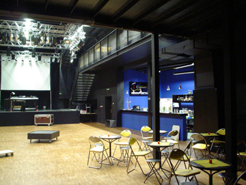 Die Halle als neue Eventhalle. Hochregale sind einer Bühne gewichen, ein schöner Parkettboden wurde verlegt, eine Bar integriert und die Wände sind in elegantem schwarz gestrichen.