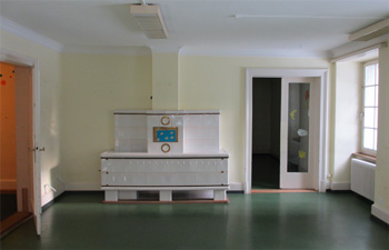 Altes Zimmer mit Linoleumboden und gelber Wandfarbe.